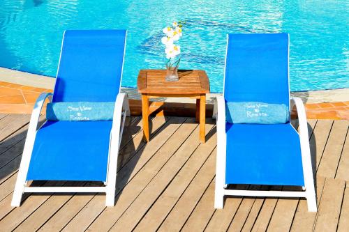 two blue chairs and a table on a deck at Sea View Resorts & Spa in Karfas