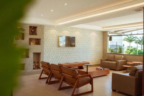 ein Wohnzimmer mit einem Tisch, Stühlen und einem Sofa in der Unterkunft Caruaru Park Hotel in Caruaru