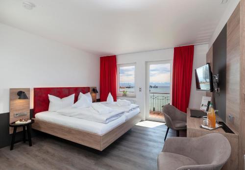 a bedroom with a large bed with red curtains at Strandhaus Eberle in Immenstaad am Bodensee