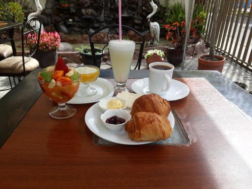 una mesa de desayuno con un plato de comida y una bebida en Hotel Golosone, en Ambato