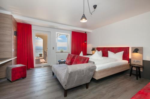 a bedroom with a bed and a couch and red curtains at Strandhaus Eberle in Immenstaad am Bodensee