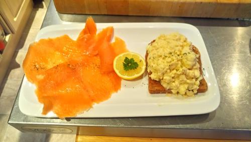 a plate of food with salmon and rice and a lemon at Camellia Lodge Guest House in Weston-super-Mare
