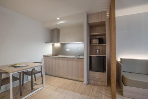 a kitchen with a refrigerator, stove, sink and a microwave at Hotel & Aparthotel Cosmos in Andorra la Vella