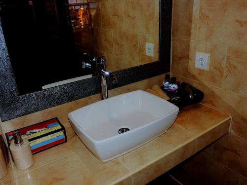 a white sink in a bathroom with a mirror at D'Coin Lembongan in Nusa Lembongan
