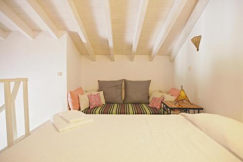a bedroom with a bed and a couch in a room at Monte da Xica - Somente Adultos in Zambujeira do Mar