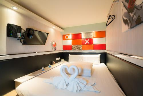 a room with a bed with a heart shaped towel at Kenting Space Capsule in Kenting