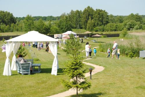 a group of people in a park with a white tent at Lavender Village in Kiemeliai