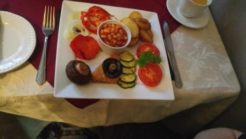 a plate of food with vegetables on a table at Camellia Lodge Guest House in Weston-super-Mare