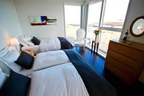 a bedroom with two beds and a large window at Brún in Laugaras