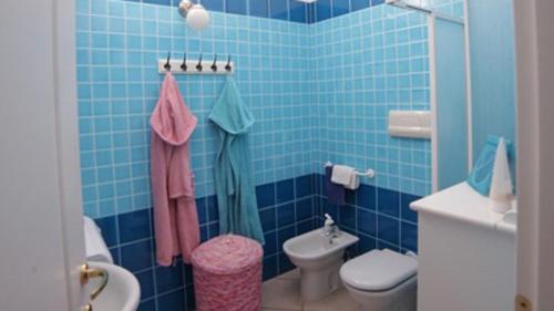een blauw betegelde badkamer met een toilet en een wastafel bij Vicino al mare nel cuore di Santa Teresa Gallura in Santa Teresa Gallura