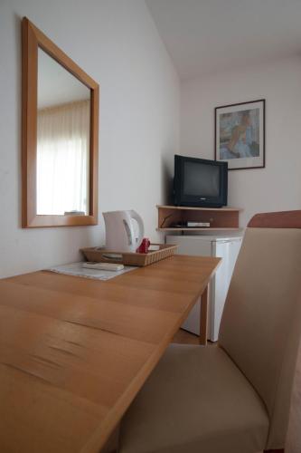 a living room with a wooden table and a mirror at Apartments Đurašević in Sveti Stefan