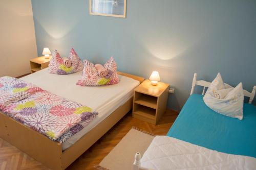 two twin beds in a small room with two lamps at Apartmani Eškinja in Biograd na Moru