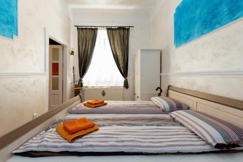 ブダペストにあるBudapestapartment9のベッドルーム内のベッド2台(オレンジのタオル付)