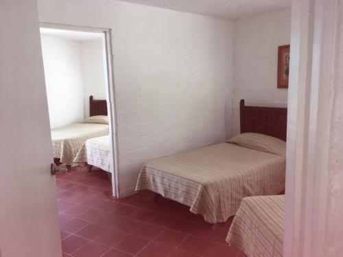 a room with two beds and a mirror at Hotel Rancho Buenavista in Los Barriles