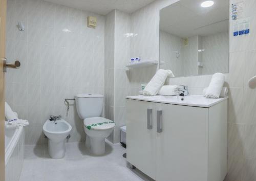 a white bathroom with a toilet and a sink at Magic Cristal Park in Benidorm
