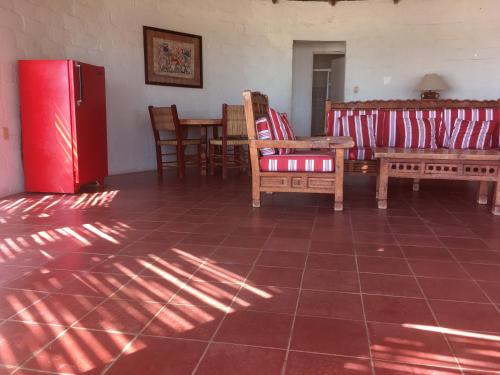 a living room with chairs and a red refrigerator at Hotel Rancho Buenavista in Los Barriles