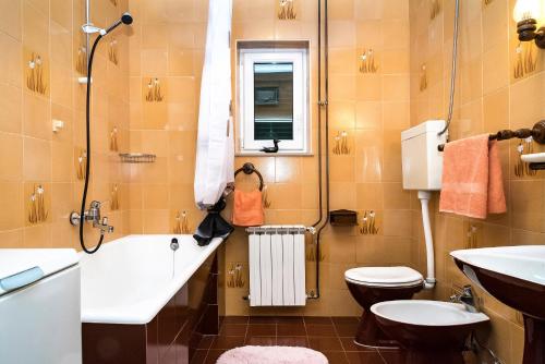 a bathroom with a tub and a toilet and a sink at Apartmani AMI in Podstrana