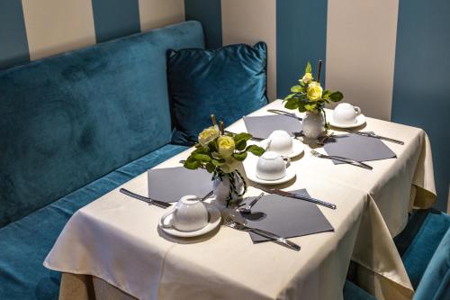 a table with plates and cups and flowers on it at Hotel Tiziano in Venice
