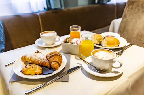 a table with two plates of food and cups of coffee at Hotel Tiziano in Venice