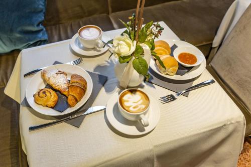 a table with two plates of food and a cup of coffee at Hotel Tiziano in Venice