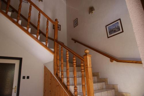 a staircase in a home with wooden railings at Butyka Ferencné Apartman in Hévíz