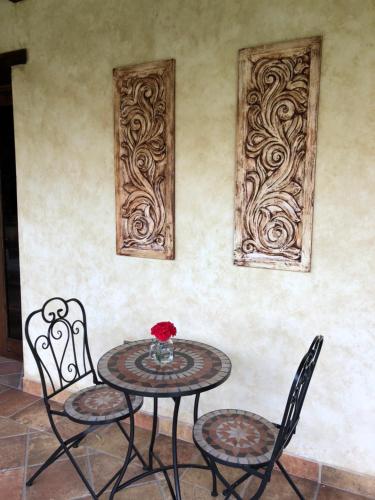 a table with two chairs and a table with a vase on it at Casa Faustina Boutique Hotel in Antigua Guatemala