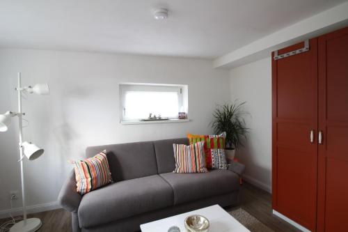 a living room with a gray couch and a window at Elbperle94 in Hamburg