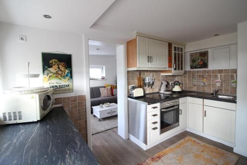 a kitchen with white cabinets and a microwave at Elbperle94 in Hamburg