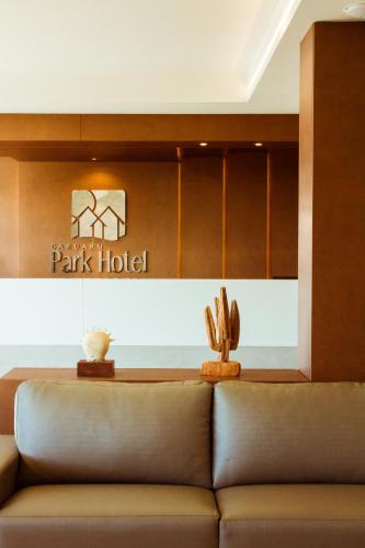 a couch in a lobby with a park hotel sign at Caruaru Park Hotel in Caruaru