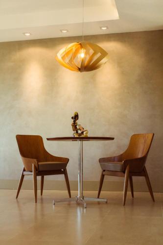 a table with two chairs and a doll sitting on top of it at Caruaru Park Hotel in Caruaru