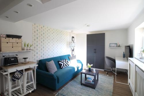 a living room with a blue couch and a table at Elbperle94 in Hamburg