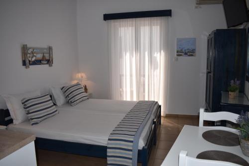 a bedroom with a large bed and a kitchen at Filippos in Adamas