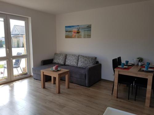 a living room with a couch and a table at Apartamenty Bursztynowe in Dębki
