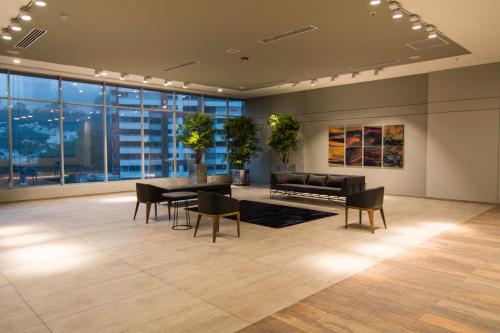 a living room with a table and chairs and a couch at Novotel Medellin El Tesoro in Medellín