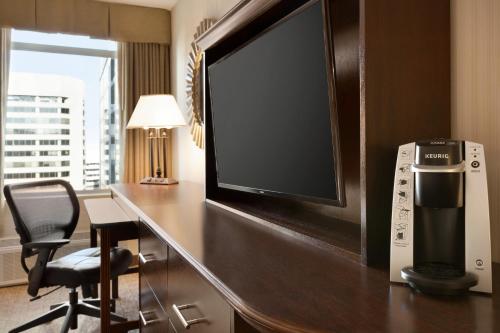 a hotel room with a desk with a tv and a chair at Crowne Plaza Crystal City-Washington, D.C., an IHG Hotel in Arlington