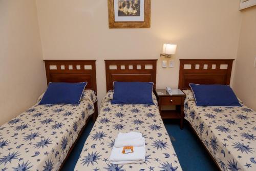 2 camas en una habitación con sábanas azules y blancas en Hotel Federico I en Concordia