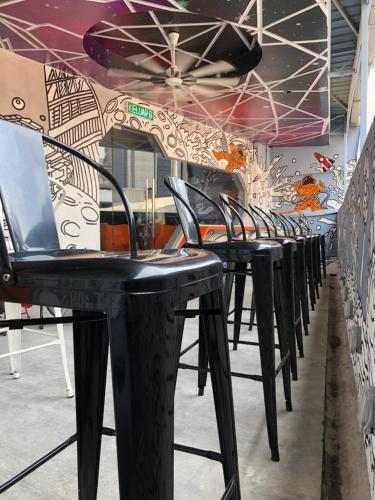 a row of black chairs against a wall with graffiti at Space Hotel @ Chinatown Kuala Lumpur in Kuala Lumpur