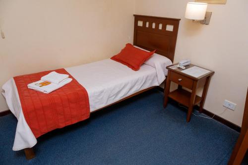 a hotel room with a bed and a nightstand with a bed sidx sidx sidx at Hotel Federico I in Concordia