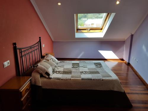 um quarto com uma cama grande e uma janela em Piso Maceira Combarro em Combarro