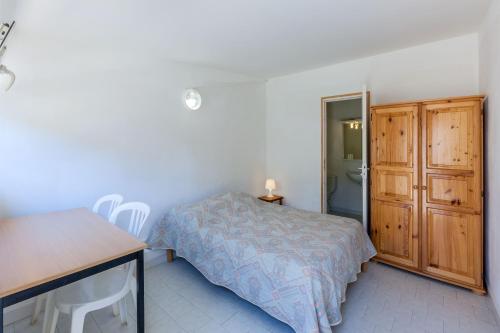 a bedroom with a bed and a desk and a table at L'Escale Plage in Algajola