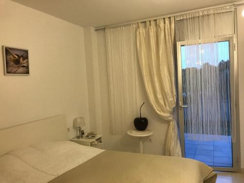 a bedroom with a bed and a large window at Paradise Village in Salou