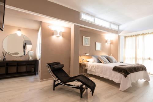 ラ・スペツィアにあるRelais Buonviaggioのベッドルーム1室(ベッド1台、椅子、鏡付)