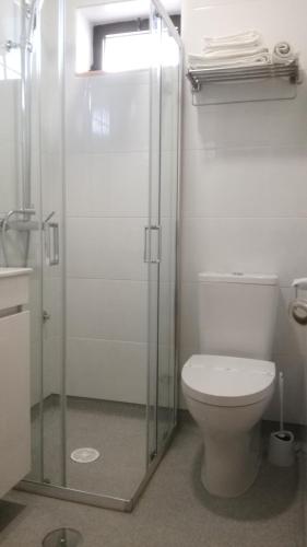 a bathroom with a toilet and a glass shower at Beira Rio do Gerês in Geres
