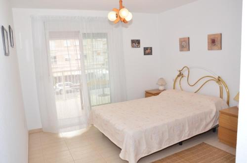 a white bedroom with a bed and a window at Aguilas Prolongación Armando Muñoz Calero in Águilas