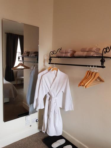 a mirror with a white robe hanging on a wall at The Old Cross Inn in Blairgowrie