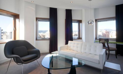a living room with a white couch and a glass table at Palacio Avenida in Palma de Mallorca