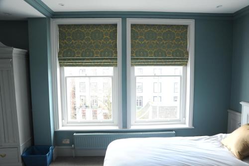 a bedroom with two windows and a white bed at The Tunbridge Wells Hotel in Royal Tunbridge Wells