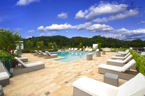 a swimming pool with lounge chairs on a building at Las Villas Marina Pez Vela in Quepos