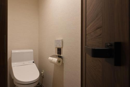 a bathroom with a toilet and a roll of toilet paper at Enoca Hotel in Fujisawa
