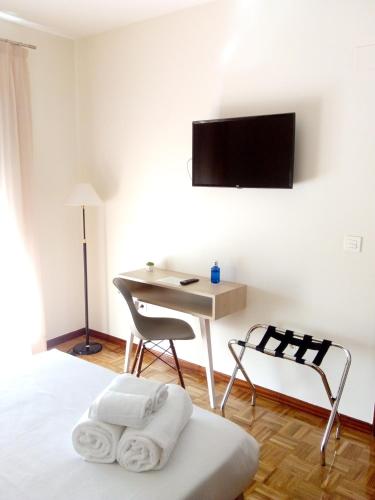 a bedroom with a bed with a desk and a tv on the wall at Hotel Puerta Ciudad Rodrigo in Ciudad-Rodrigo